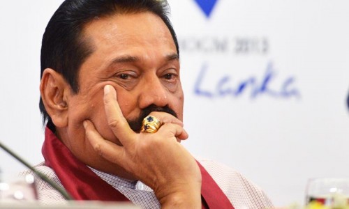 Sri Lanka President Mahinda Rajapaksa listens during a press conference during the Commonwealth Heads of Government Meeting (CHOGM) in Colombo on November 16, 2013.  Britain's David Cameron put Sri Lanka on notice to address allegations of war crimes within months or else he would lead a push for action at the UN.  AFP PHOTO/ISHARA KODIKARA